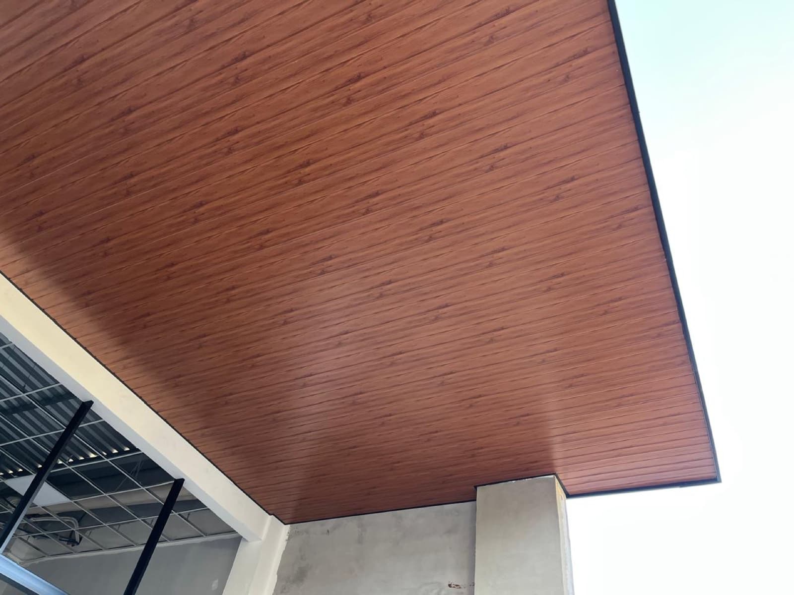 Vista ampla de forro amadeirado instalado em área externa coberta