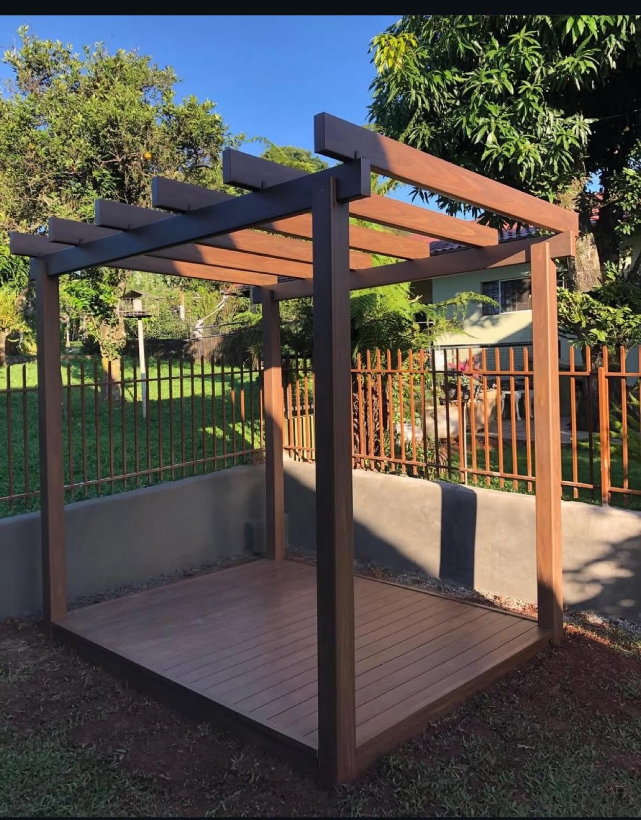 Deck e pergolado instalados em jardim residencial