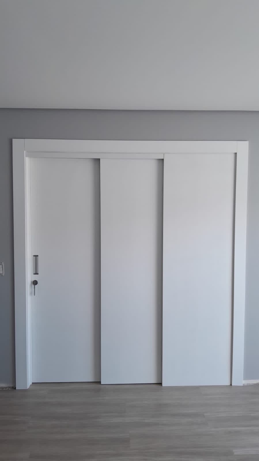 Porta branca de correr com três folhas em vão amplo