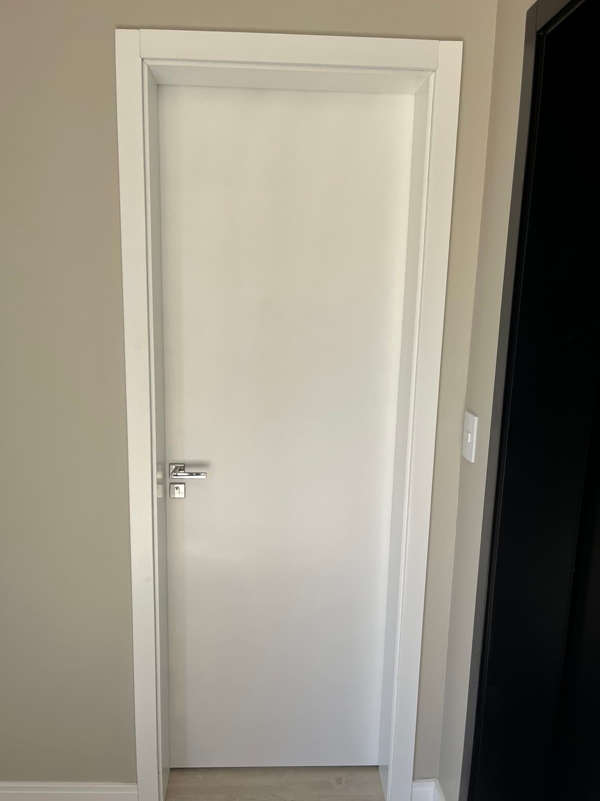 Porta branca interna com rodapé e piso claro